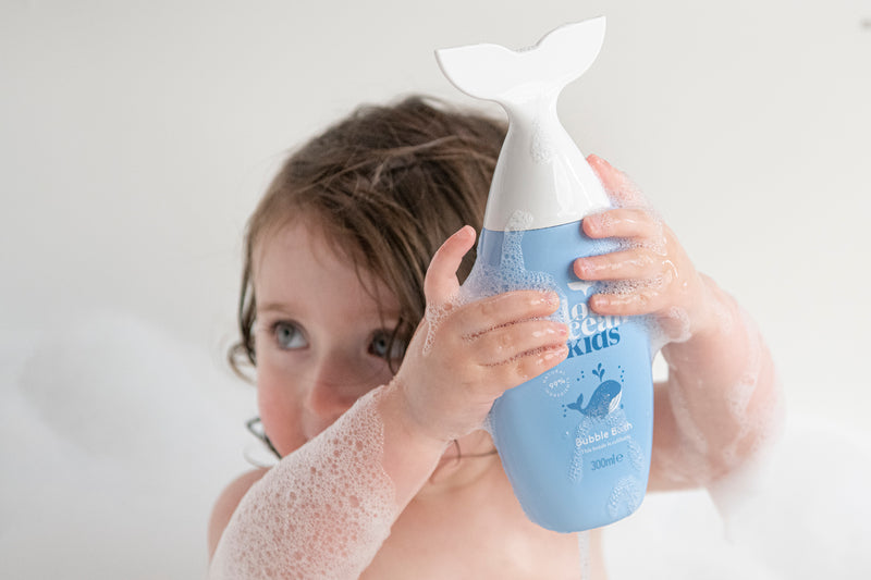 Baby with bottle of Hair and Body Wash Love Ocean Kids